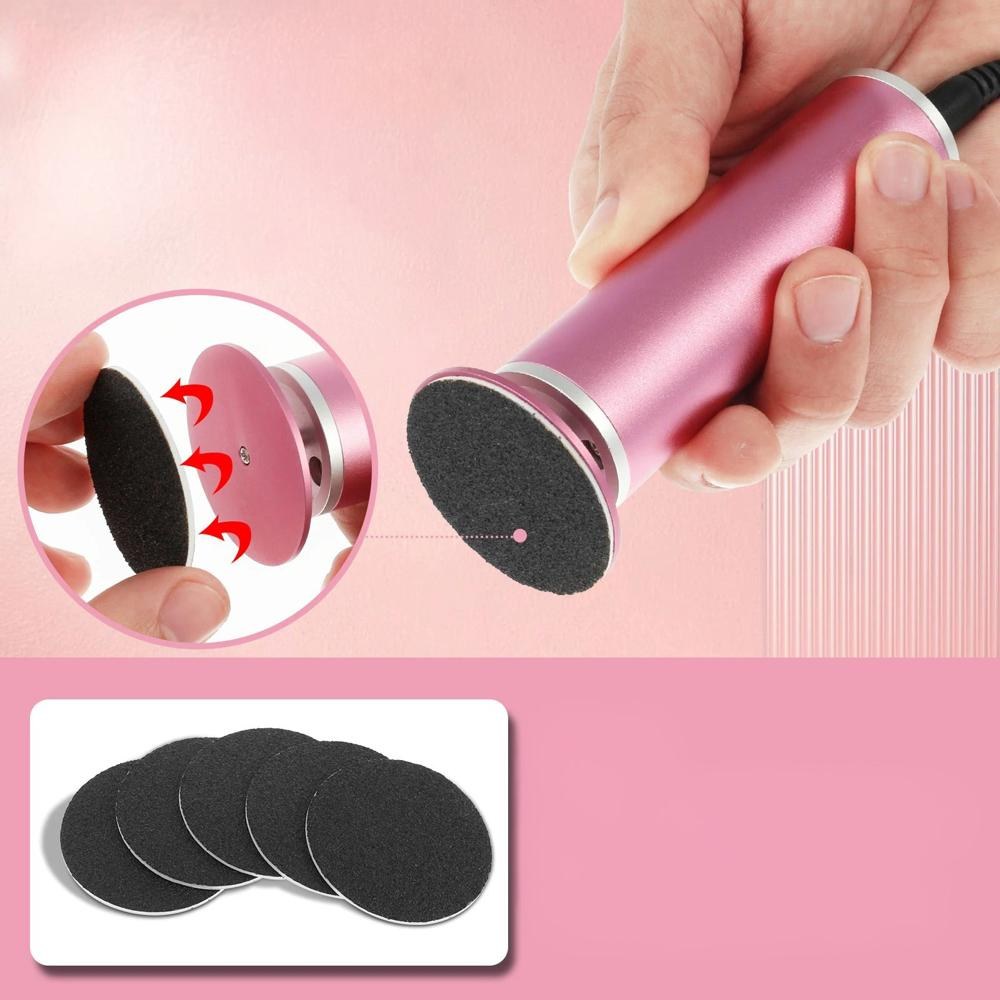 Pink electric foot file held in hand showing detachable sanding disc