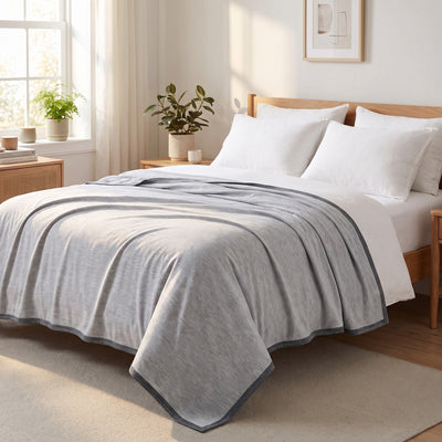 Lightweight cooling blanket covering a bed with morning light