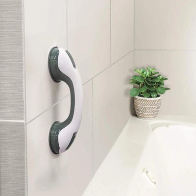 Suction cup grab bar mounted on bathroom tile wall near bathtub