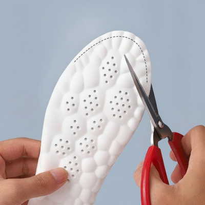 Scissors trimming shoe insole along dashed guide line