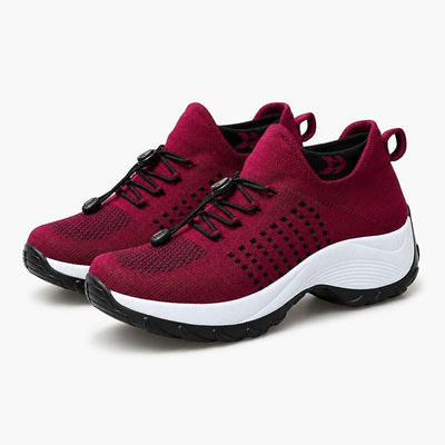 Red cushioned walking shoes pair on white background