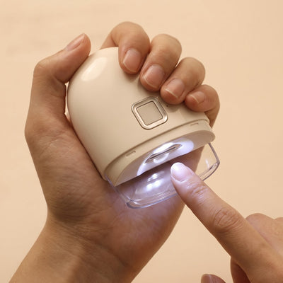Hand holding electric nail clipper with LED glowing