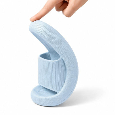 Blue slide slipper bent to show flexible EVA foam material