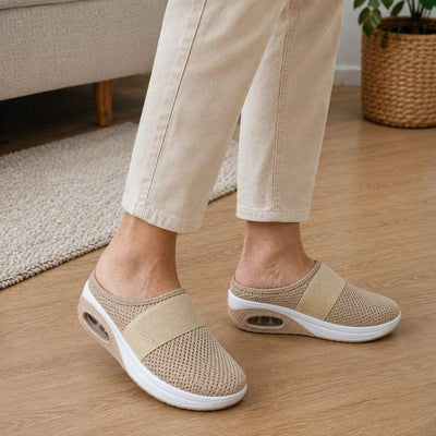 Beige slippers worn on hardwood floor at home