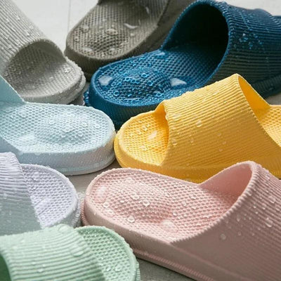 Multiple colorful heel slippers with water droplets showing water resistance